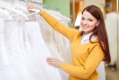 pretty bride chooses  wedding dress in bridal salon